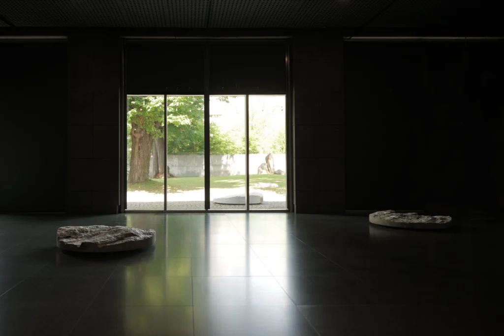 View of Primes by Ewa Wes Wesołowska at the Manggha Museum, showing two granite sculptures inside and two outside in the Japanese garden