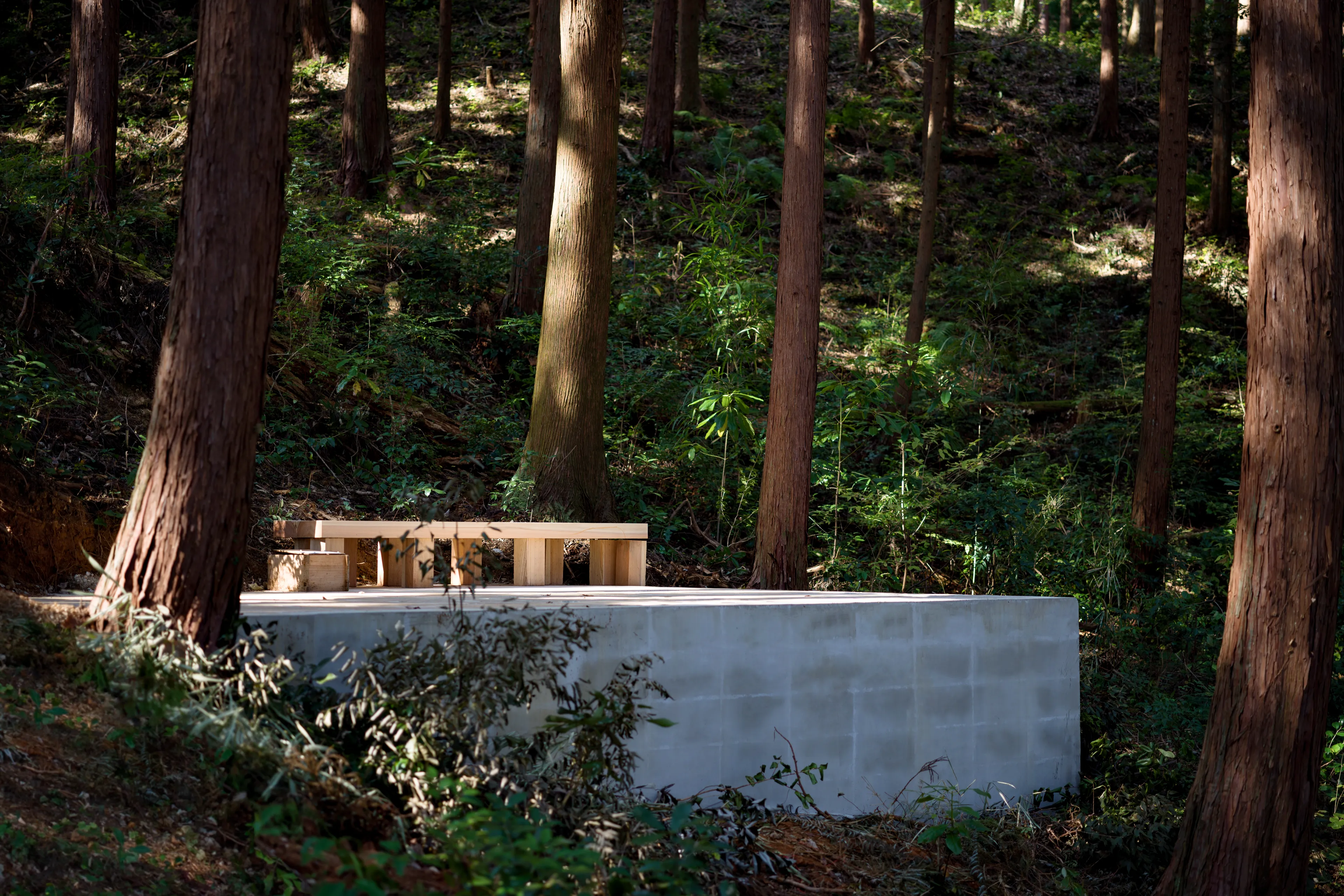 Liminality, an interactive public artwork by Ewa Wes (Wesołowska) in Kamiyama, Japan, featuring carved stone and a wooden bench.