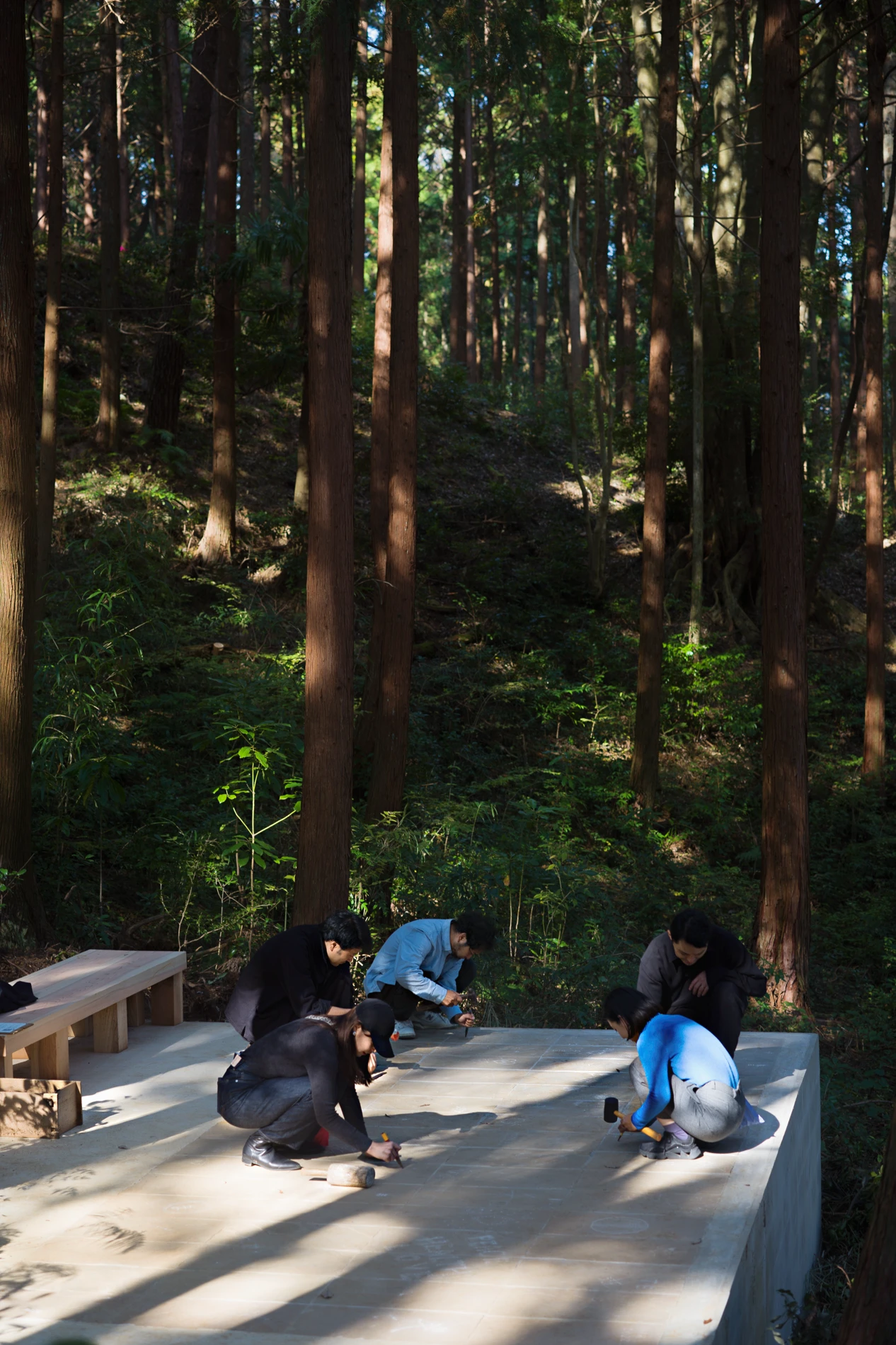 People engraving marks on stone at Liminality, a participatory public artwork by Ewa Wes in Kamiyama, Japan.