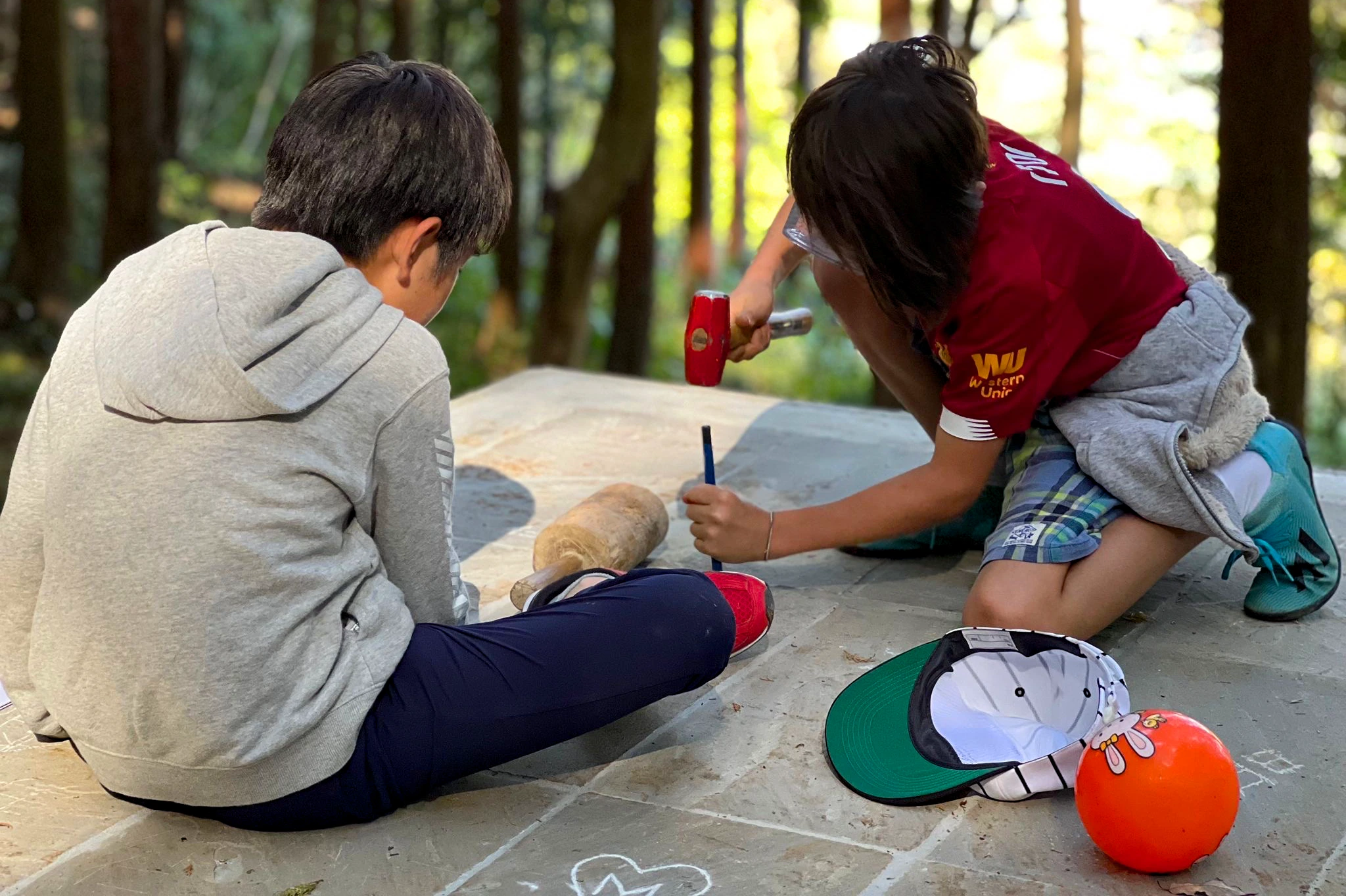 This image captures two boys carving in stone floor of Liminality, an interactive public artwork by Ewa Wes (Wesołowska) in Kamiyama, Japan.