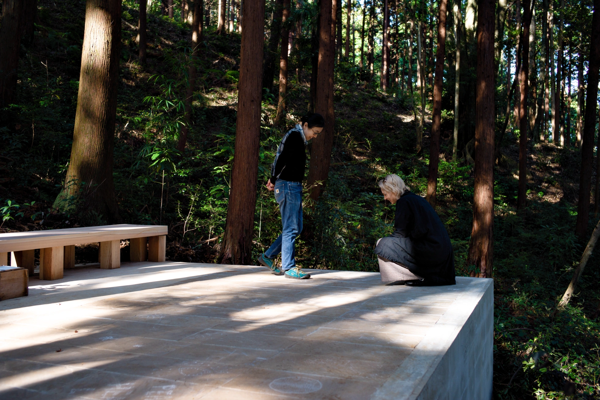 People observing carved traces in stone at Liminality, a site-specific installation by Ewa Wes (Wesołowska) in Kamiyama, Japan.