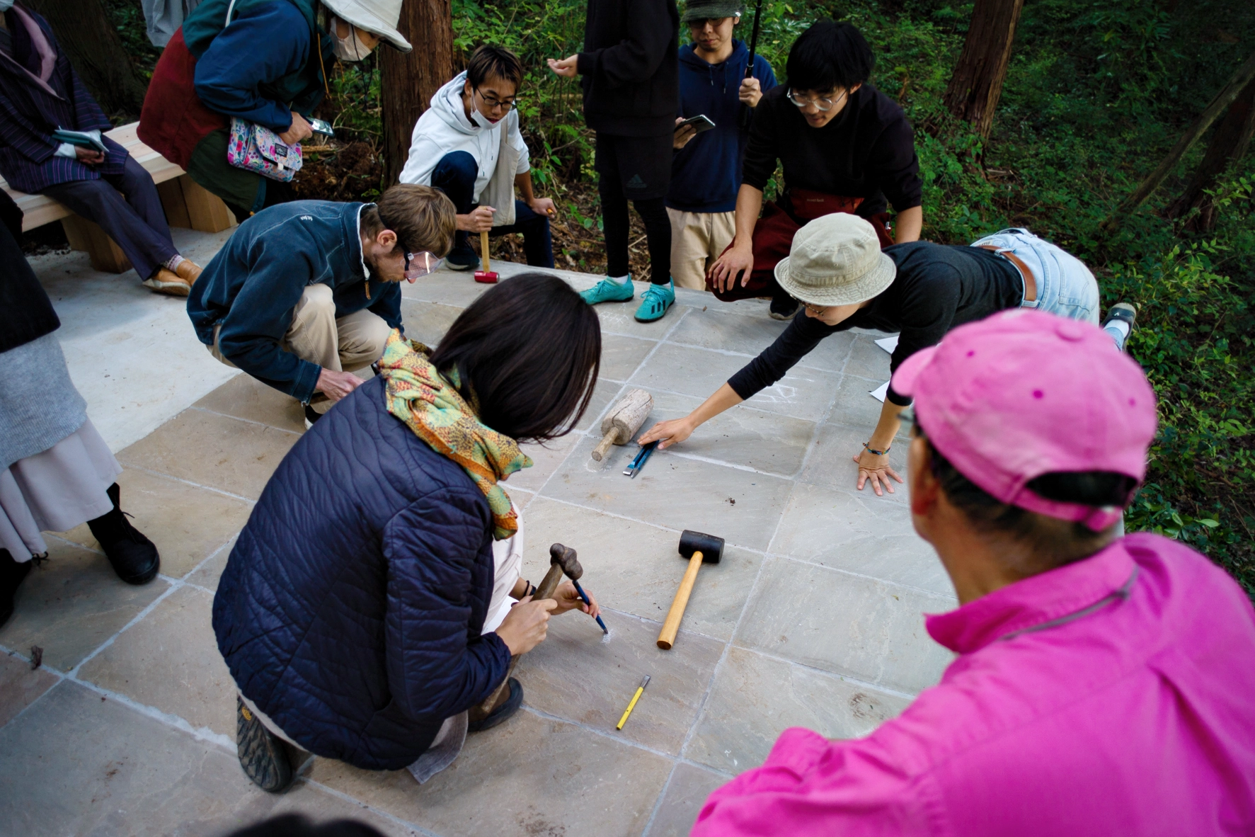 Participants carve their traces into the stone surface of Liminality, an interactive public artwork by Ewa Wes (Wesołowska) in Kamiyama, Japan.
